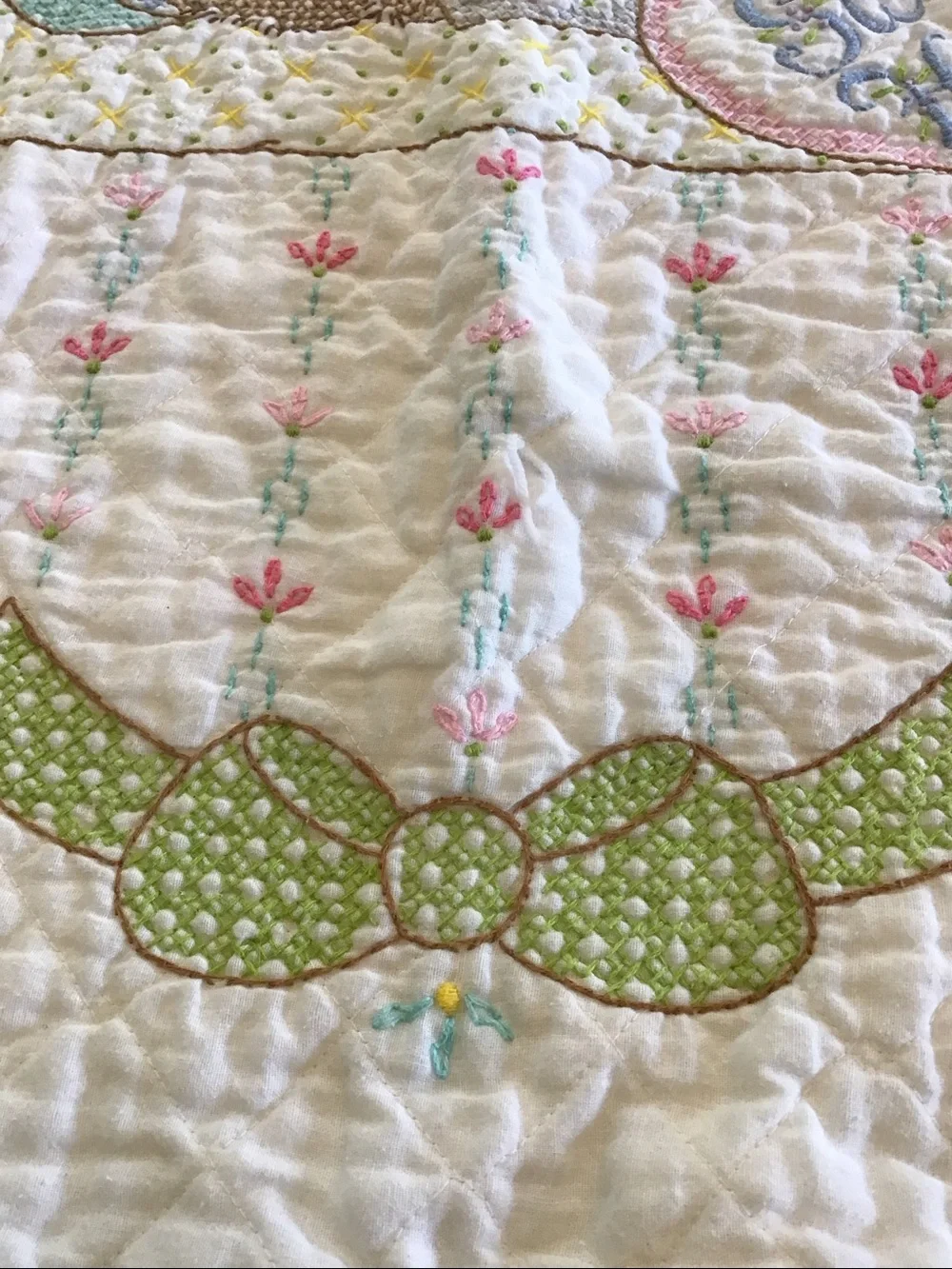 Vintage handmade baby quilt featuring embroidered teddy bears